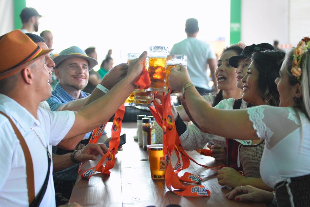 imagem mostra pessoas brindando com cerveja